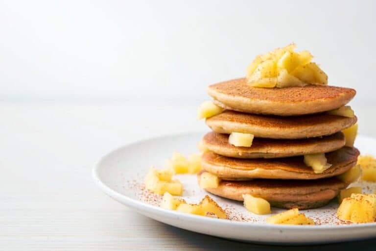 Crêpes aux pommes sur assiette blanche.