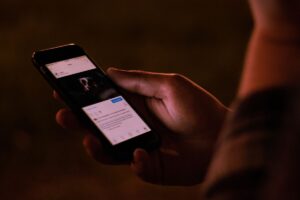 Main tenant un smartphone avec application ouverte.
