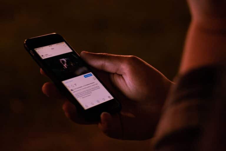 Main tenant un smartphone avec application ouverte.