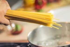 Spaghettis ajoutés à une marmite d'eau bouillante.