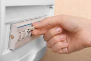 Main ajustant le disjoncteur électrique.