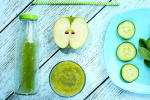 Smoothie vert, pomme, concombre et menthe sur table.