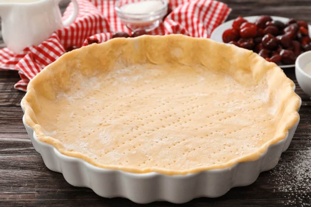 Fond de tarte non cuit dans un plat blanc.