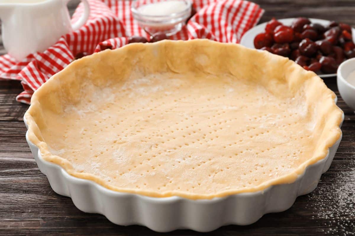 Fond de tarte non cuit dans un plat blanc.