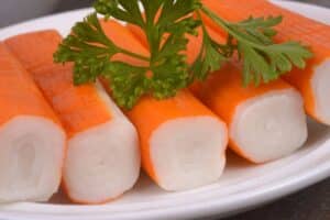 Surimi avec persil sur assiette blanche.