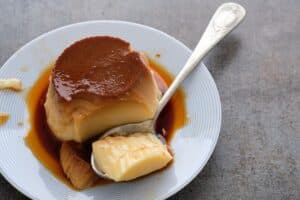 Flan au caramel dans une assiette avec cuillère.