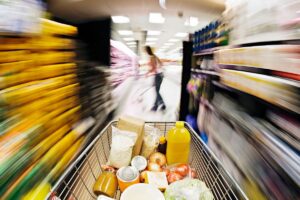 Caddie plein dans une allée de supermarché floue.