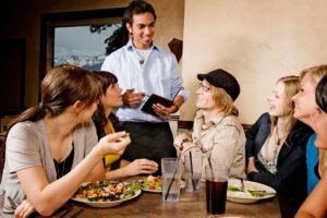 Serveur prenant commande d'un groupe au restaurant.