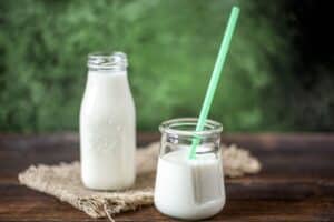 Deux bouteilles de lait sur table en bois.